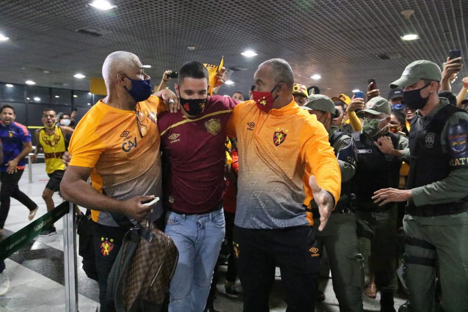 Thiago Neves se esquiva de torcedores em sua chegada em Recife